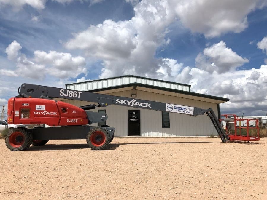 A Skyjack SJ86T boom lift parked in front of the Rental King building in Odessa, Texas.